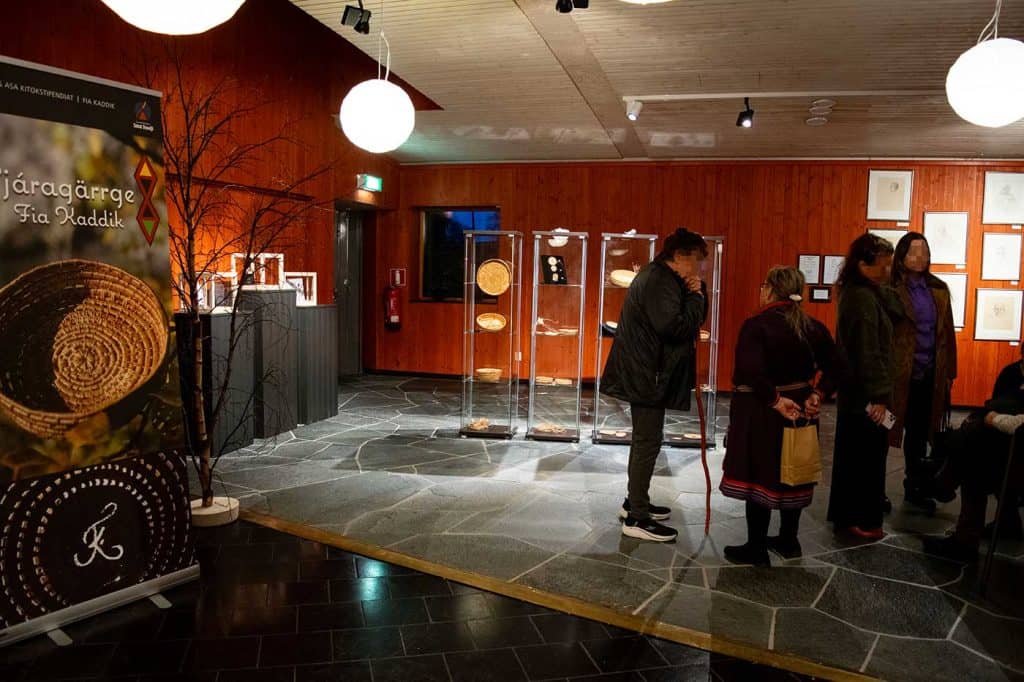 En bild av några människor som besöker en utställning i Silvermuseet. I montrarna syns rotslöjd. 
