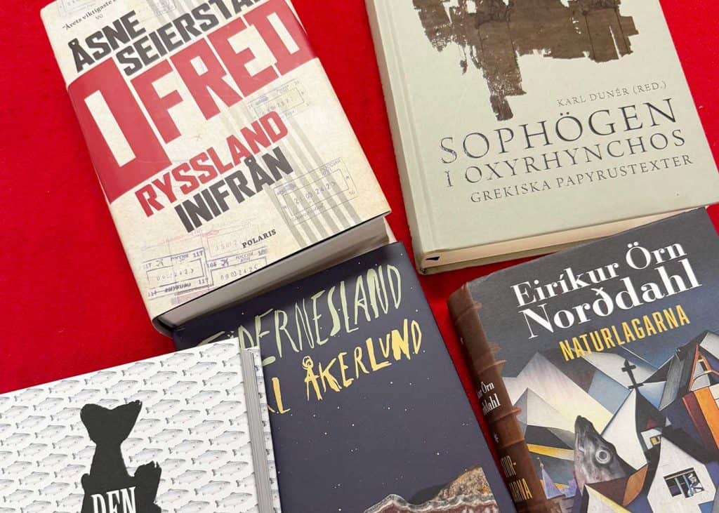 Bild på böcker som ligger på ett bord. Bilden är beskuren så att man inte kan se alla titlar och författare. De som syns är ”Ofred”, ”Sophögen i Oxyrhynchos” och ”Naturlagarna”.